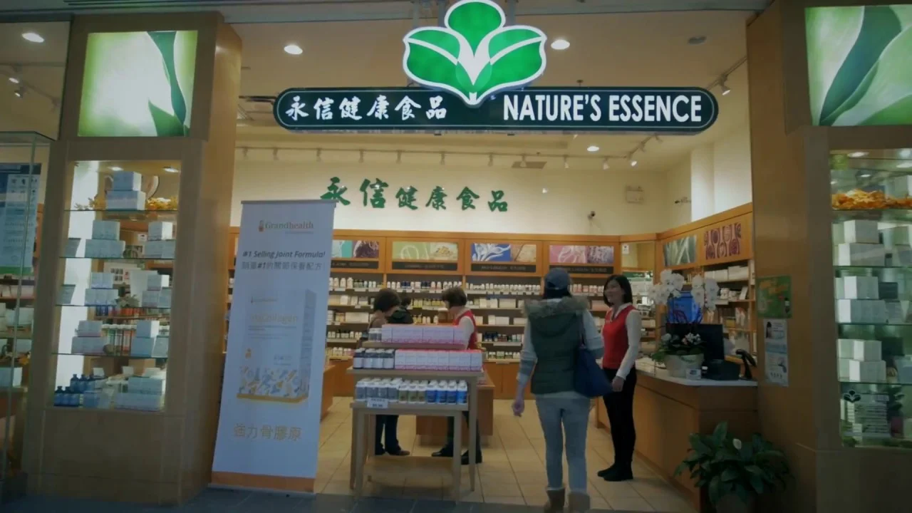 Nature’s Essence storefront in a historical promotional film, showing its bilingual sign and product displays