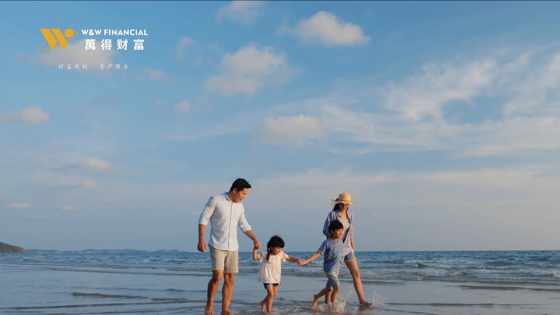 企业宣传片中的家庭海滩画面，两名成人与两名孩子牵手走在海边